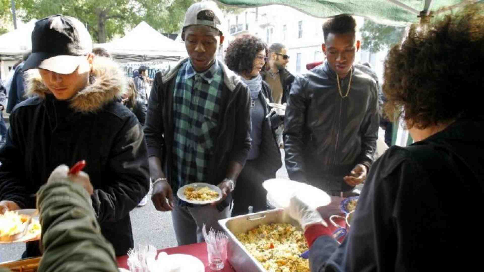 Novembre 2017, alcuni cittadini milanesi servono alcuni migranti ospiti della caserma Montello (foto LaPresse)