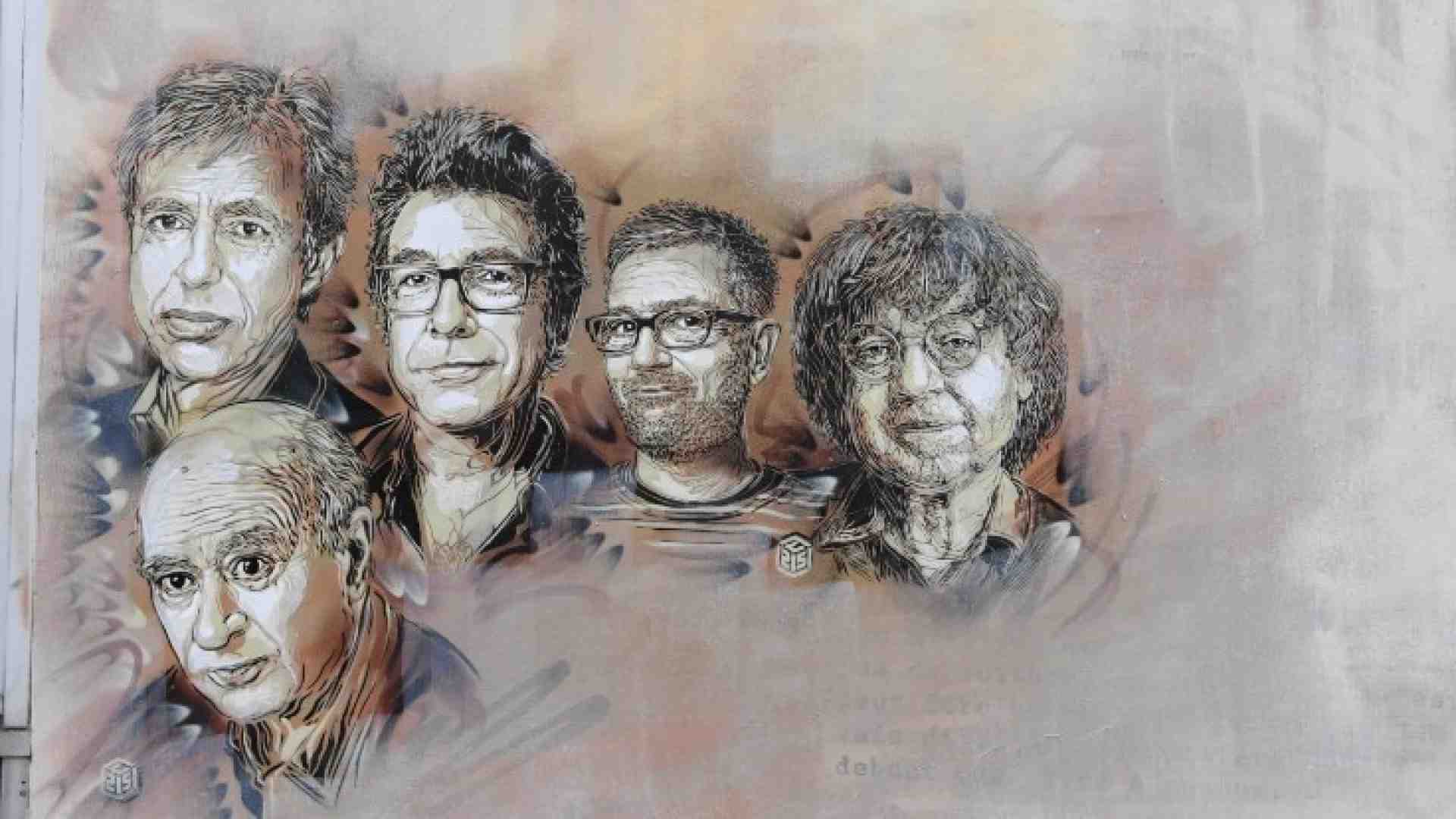 I ritratti di Georges Wolinski, Bernard Verlhac, Stephane Charbonnier e Jean Cabut su un muro di rue Nicolas Appert (foto LaPresse)