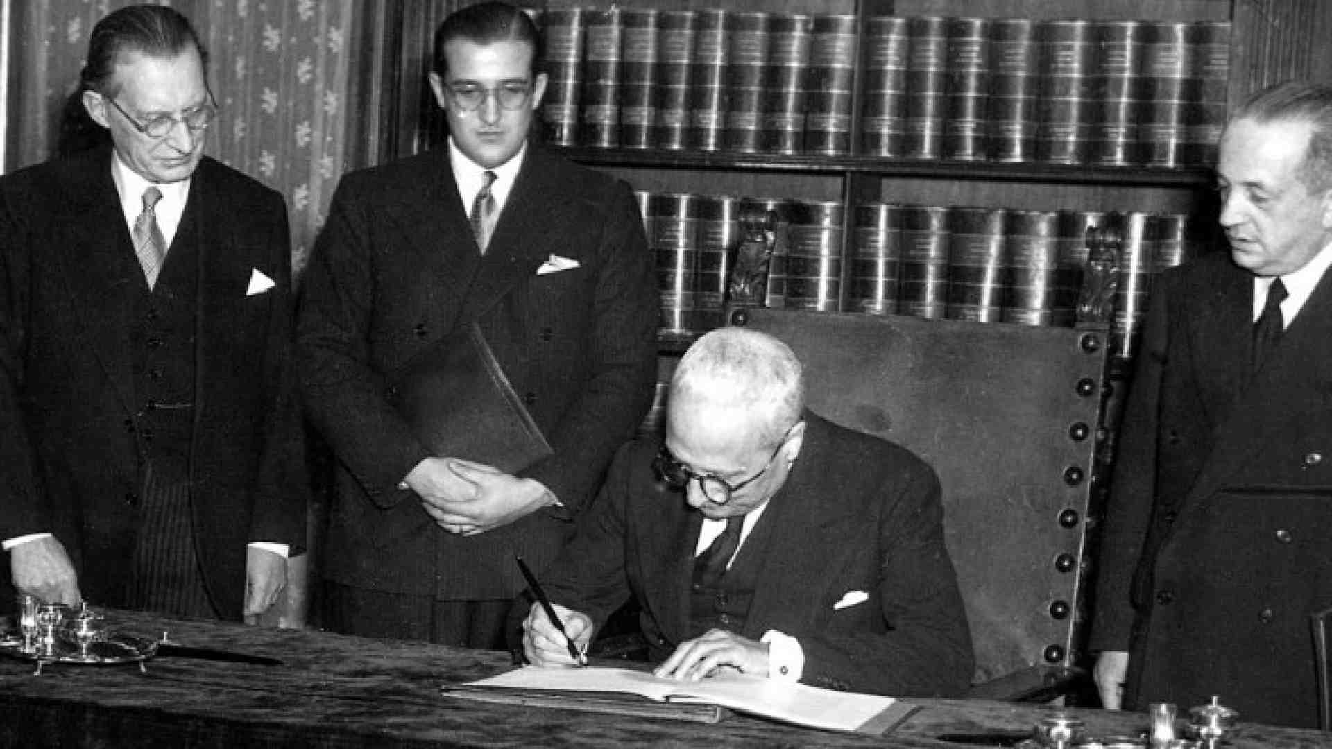 Il presidente della Repubblica, Enrico De Nicola, firma la Costituzione. Ultimo sinistra, Alcide De Gasperi (foto LaPresse)
