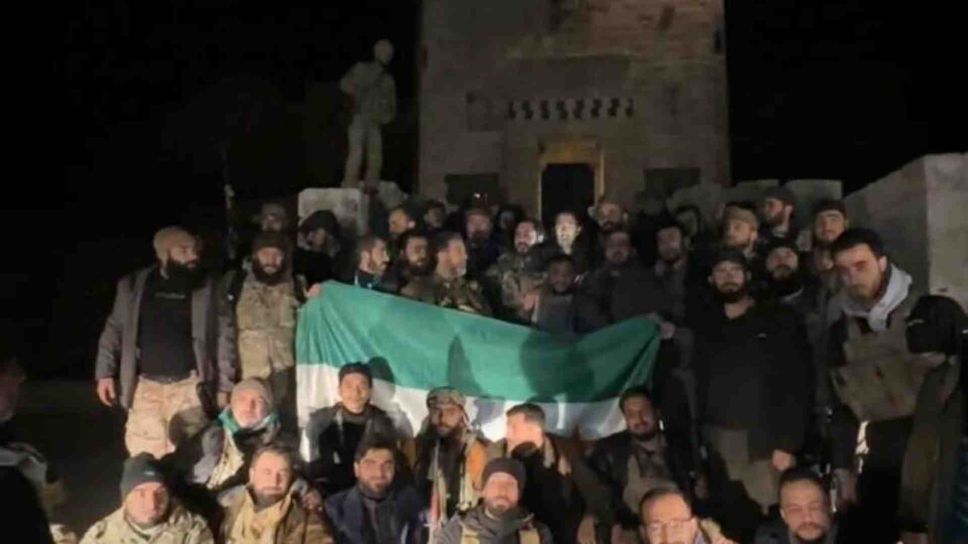  I ribelli posano per una foto davanti alla Cittadella di Aleppo liberata dal regime 