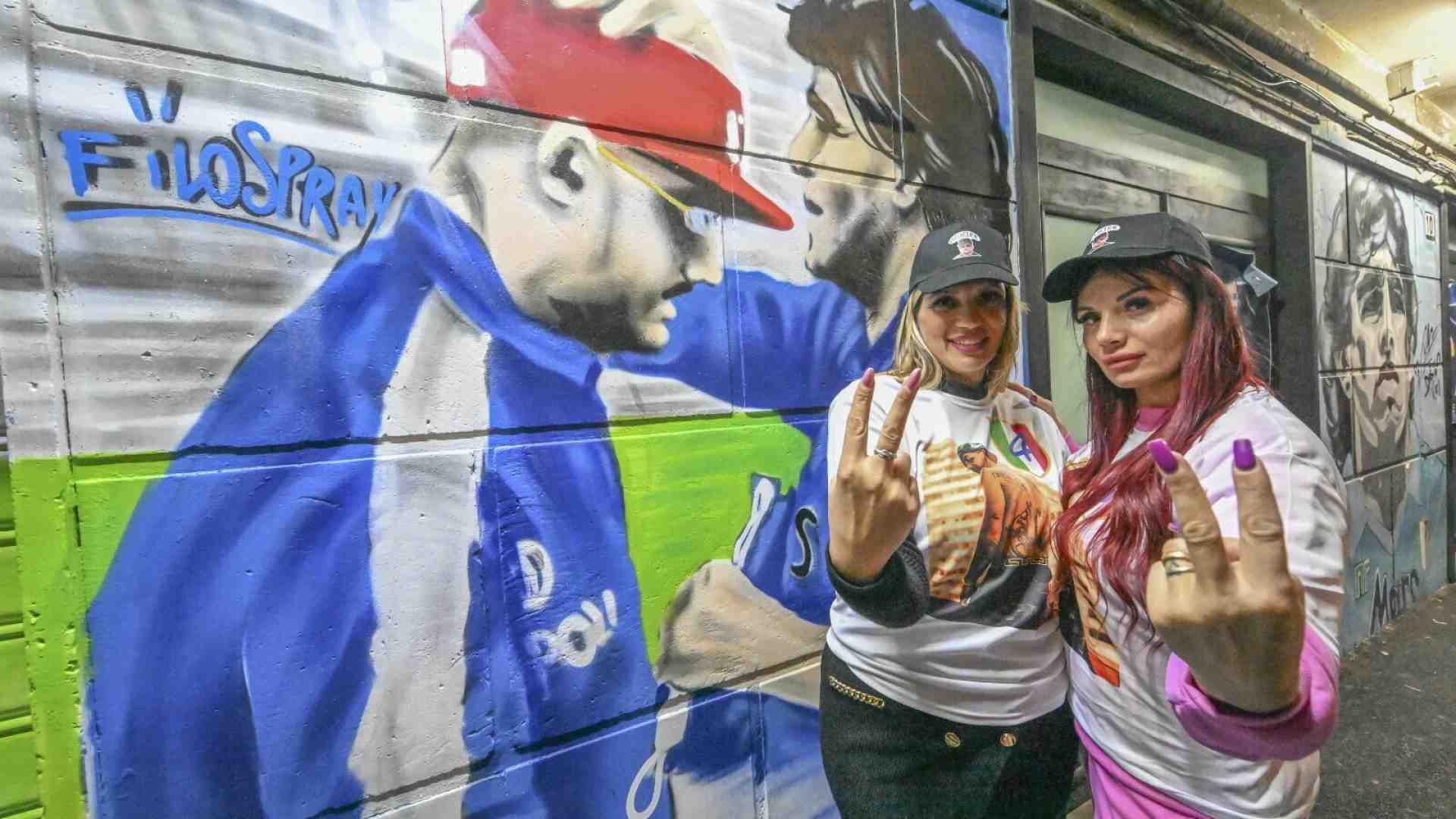 Fan di Geolier davanti al murales del musicista benedetto da Maradona (Ansa) 