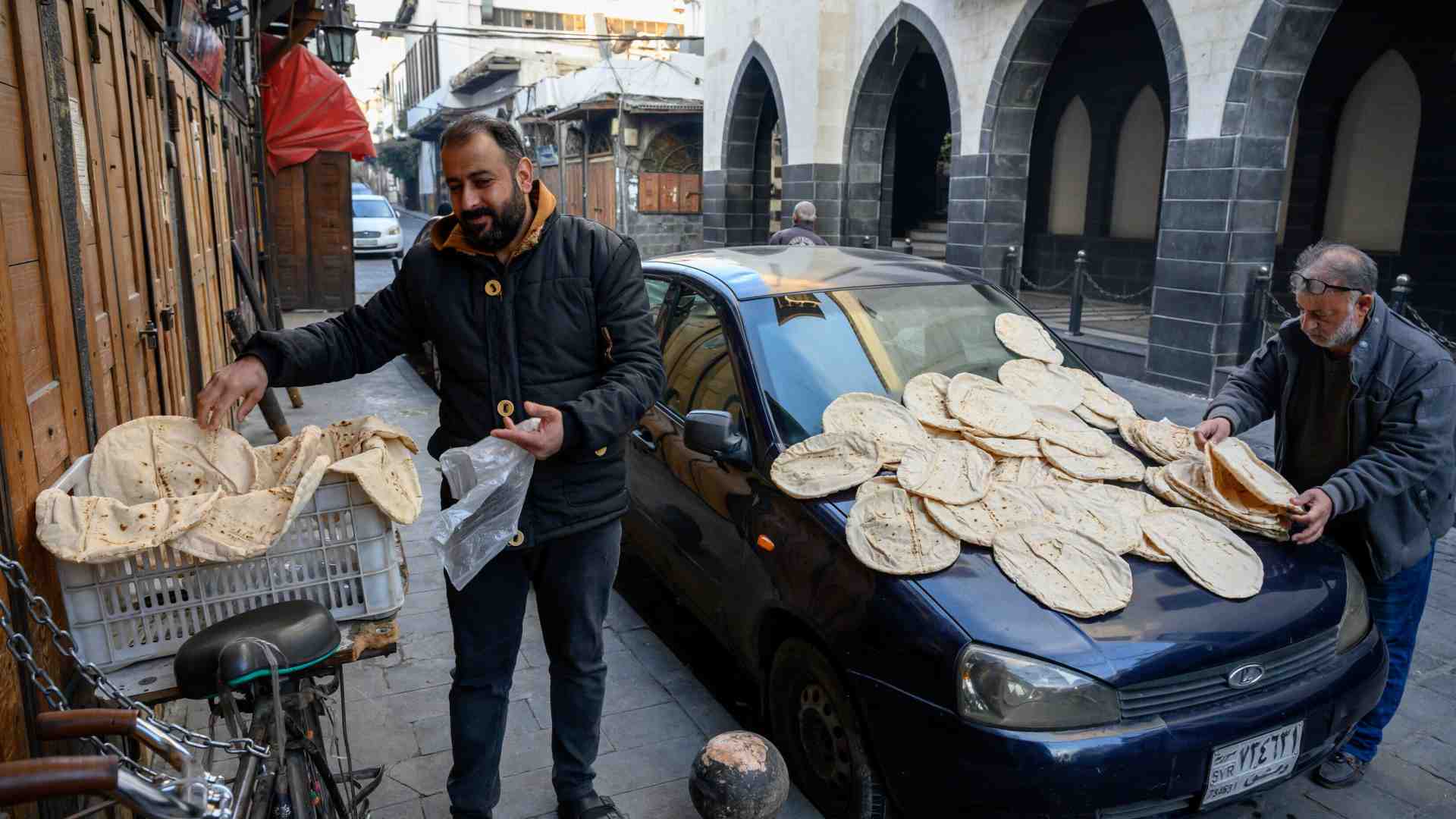 A Damasco due uomini stendono il pane appena sfornato (foto Getty)