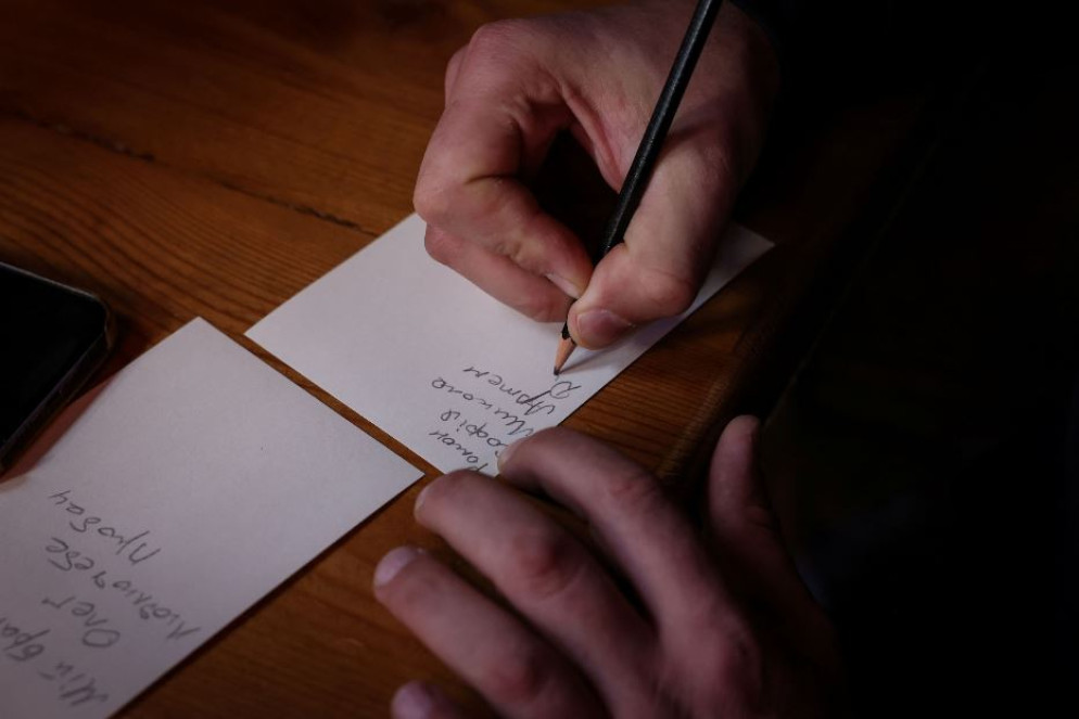 Un soldato scrive su un foglietto il nome delle persone per le quali pregare - Reuters / Alexandros Avramidis