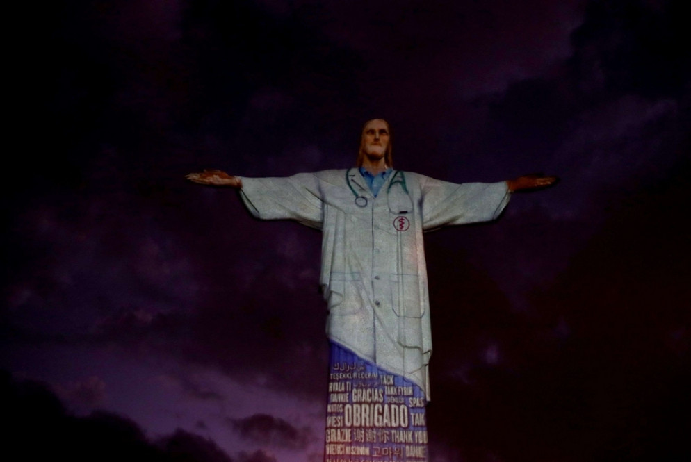 La statua del Cristo Redentore, alta 37 metri e posta sull'altura che sovrasta Rio de Janeiro, illuminata con un camice da medico