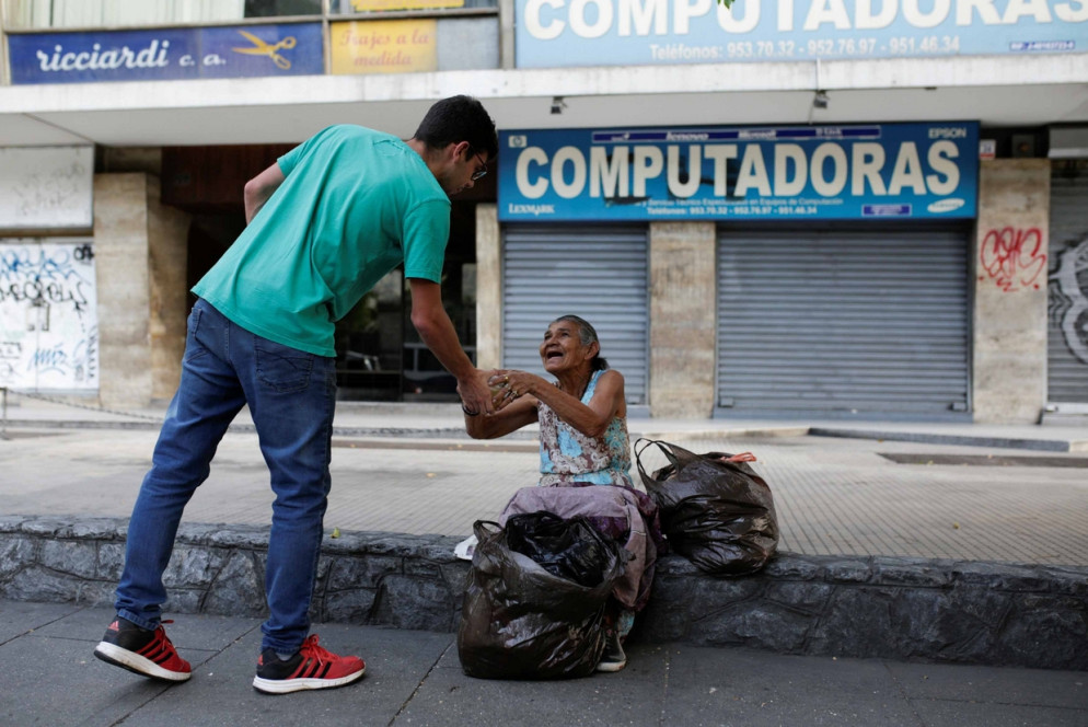 Un volontario porta i pasti ai poveri a Caracas