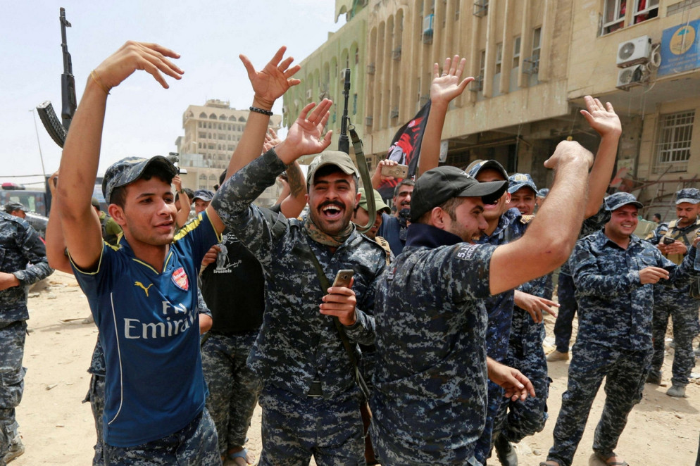 Agenti della polizia irachena esultano nella città vecchia di Mosul (Reuters)