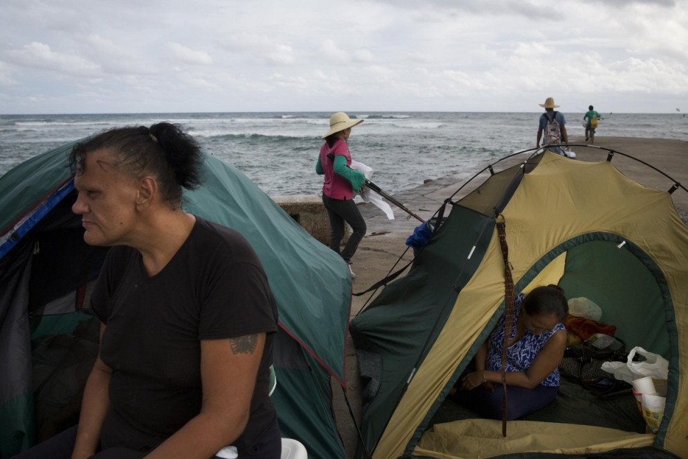 Due senzatetto riposano nelle loro tende piantate al Kewalo Basin Harbor di Honolulu: le Hawaii hanno il maggior numero di homeless negli Usa in rapporto alla popolazione (Ansa)