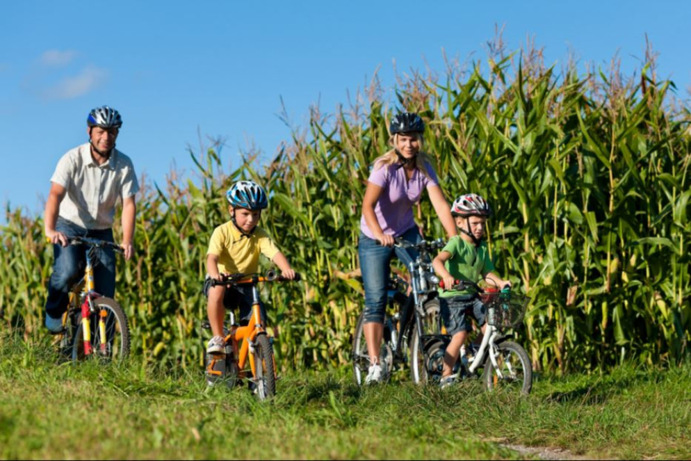 Una famiglia in bici fra i campi - © Icp