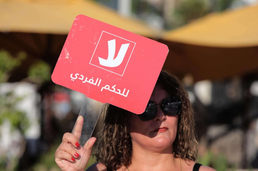 Una manifestante tunisina mostra il cartello "No all'autocrazia" per protestare contro le modifiche della Costituzione che rafforzerebbero i poteri del presidente Said - Ansa