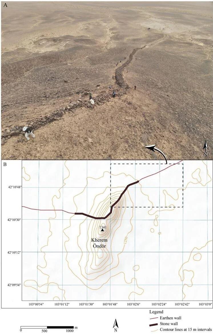 Fotografia aerea scattata da drone che mostra la sezione del muro in pietra conservata che attraversa il pendio (A). Mappa topografica che illustra la posizione strategica del muro sulla cima del Kherem Öndör, con segmenti differenziati di muro in terra (linea rossa) e in pietra (linea nera) (B) - D Golan et al., Land (2025)