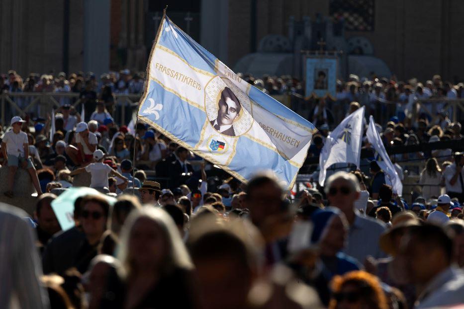 Il volto di Pier Giorgio Frassati fra la folla in piazza San Pietro per la canonizzazione di Pier Giorgio Frassati e Carlo Acutis - Ansa
