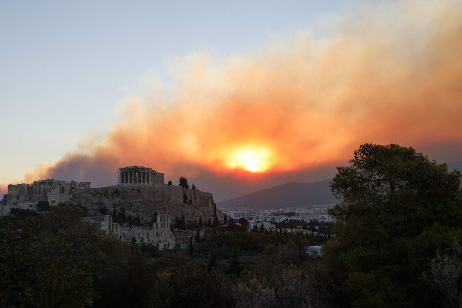 Il fumo dell'incendio si alza alle spalle del tempio del Partenone, sulla cima dell'acropoli della capitale greca (Foto Getty)